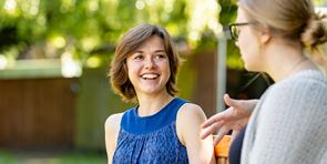 Two female academics smiling and chatting