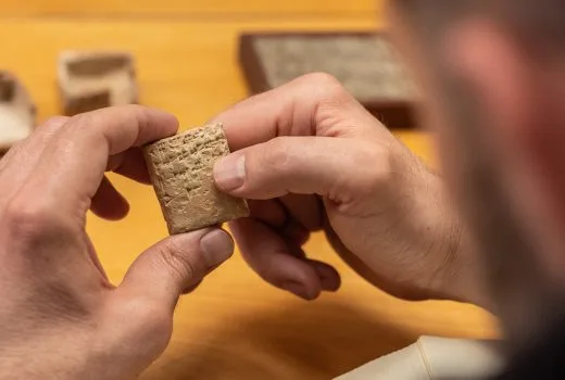 researcher looking at cuneiform tablet
